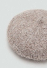 Svetlobéžový vlnený baret s jemnou, chlpatou textúrou a mierne zvýšeným stredom. Guľatý tvar bez viditeľných vzorov alebo kovových častí.