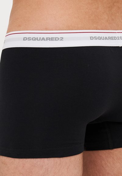 Black cotton boxer shorts with a snug fit. Features a white waistband with red and gray stripes and printed "DSQUARED2" logo.