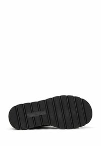 Black rubber shoe sole with a textured, ridged pattern and rounded toe. Flat profile with horizontal grooves for traction.