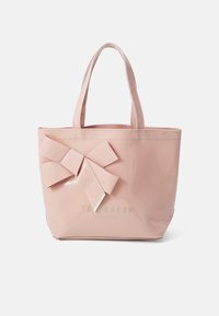 Sac fourre-tout en simili cuir rose avec un grand nœud sur un côté et une finition dorée. Équipé de deux poignées robustes pour un transport facile.