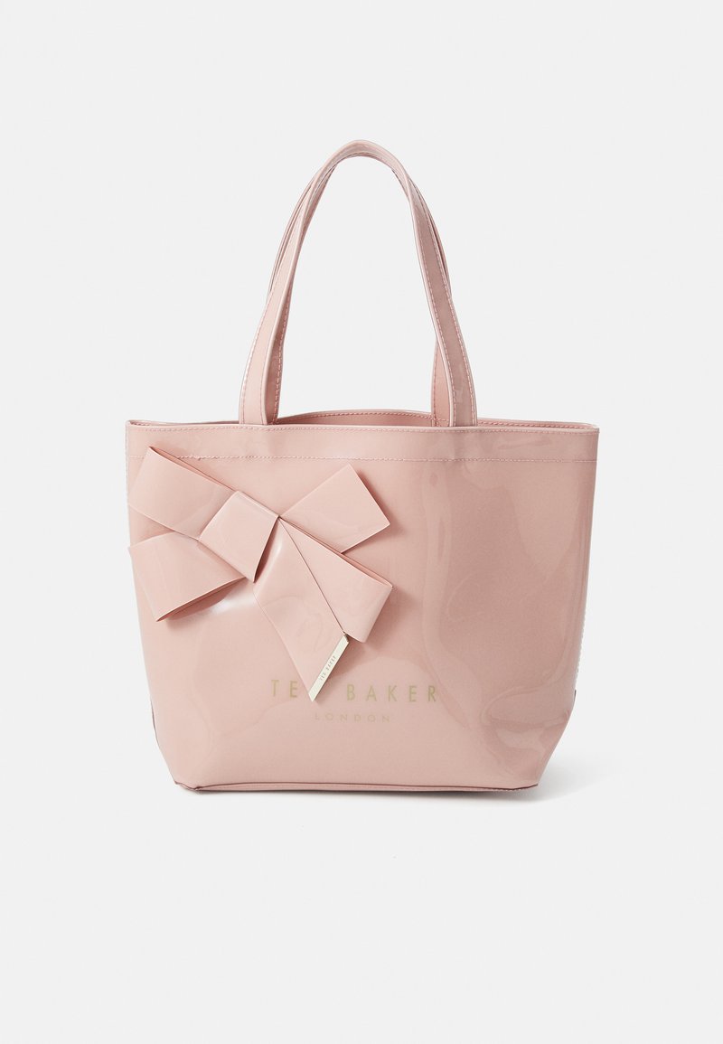 Sac fourre-tout en simili cuir rose avec un grand nœud sur un côté et une finition dorée. Équipé de deux poignées robustes pour un transport facile.