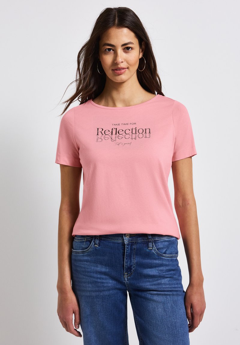 Rosa Baumwoll-T-Shirt mit rundem Halsausschnitt und kurzen Ärmeln, mit dem Text "Nehmen Sie sich Zeit für Reflexion" in Schwarz auf einem hellrosafarbenen Hintergrund.