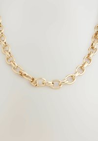 Gold metal chain necklace with interconnected oval links, polished finish, and varying link sizes for texture and visual interest.