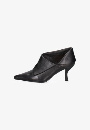 Scarpa nera in pelle con tacco alto, dalla punta appuntita, caratterizzata da un design sovrapposto nella parte anteriore e un sottile tacco a stiletto.