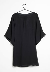 Schwarzes, durchsichtiges Kleid mit lockerer Passform, weiten Ärmeln und gerafftem Detail am Rücken, das an einem schwarzen Haken vor einem weißen Hintergrund hängt.