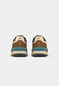 Brown and cream sneakers with a turquoise midsole, featuring a padded collar, textured upper, and prominent orange '87' detail at the heel.