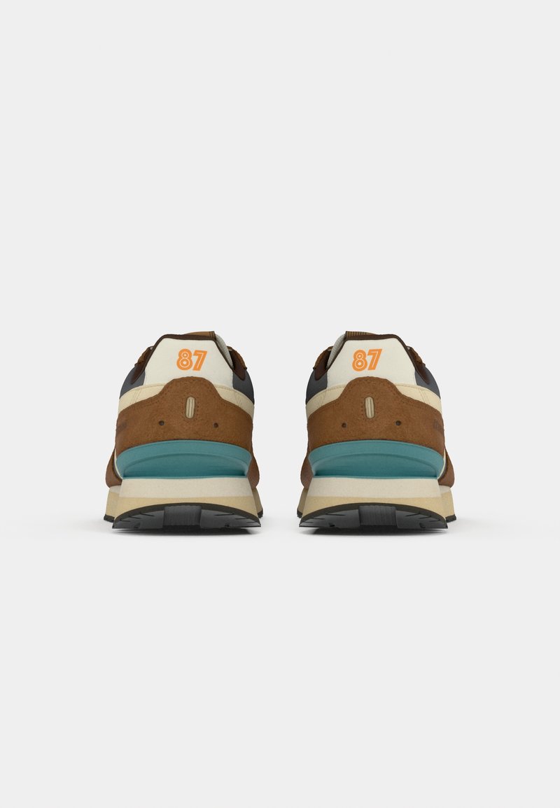 Sneaker marrone e crema con suola intermedia turchese, dotate di colletto imbottito, tomaia testurizzata e un evidente dettaglio arancione '87' sul tallone.
