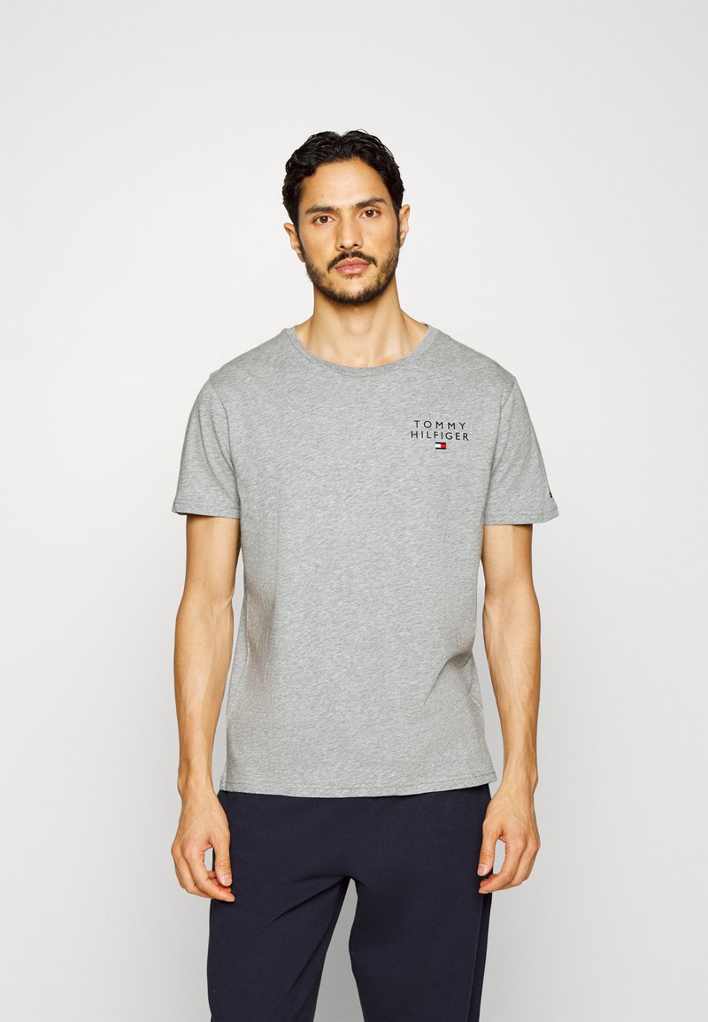 Szürke pamut póló, kerek nyakkal és rövid ujjakkal, a mellkason "TOMMY HILFIGER" logónyomattal. Kényelmes szabás, sima textúra.