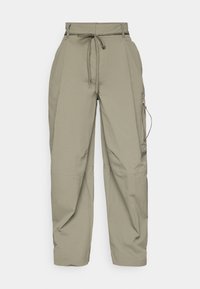 Calças cargo verde-oliva claras com cintura ajustável, corte largo e bolsos laterais com fecho. Feitas de um material leve e texturizado.