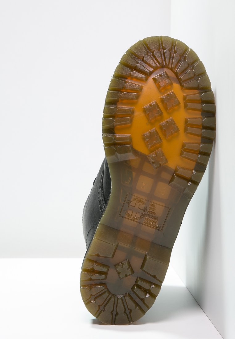 Sorte skosåle med et struktureret grebmønster, der har dybe såler og en orange bund. Materialet synes at være gummieret med indgraverede detaljer.