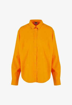 Knappe skjorte i sterke oransje farger, med klassisk krage, lange ermer og buet nederkant. Laget av lett stoff med en glatt tekstur.