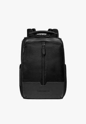 Mochila negra con cuerpo de tela texturizada y detalles de cuero liso, con asa superior, correas ajustables y bolsillos frontales con cremallera.