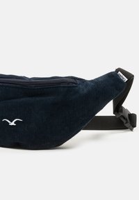 Navyblaue Cordura-Gürteltasche mit einem Reißverschlussfach und verstellbarem schwarzen Träger. Auf der Vorderseite befindet sich ein kleines weißes Logo.