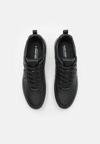 Czarne sneakersy z perforowanej skórzanej cholewki, sznurowanym zapięciem i białą gumową podeszwą. Posiadają logo na języku i boku.