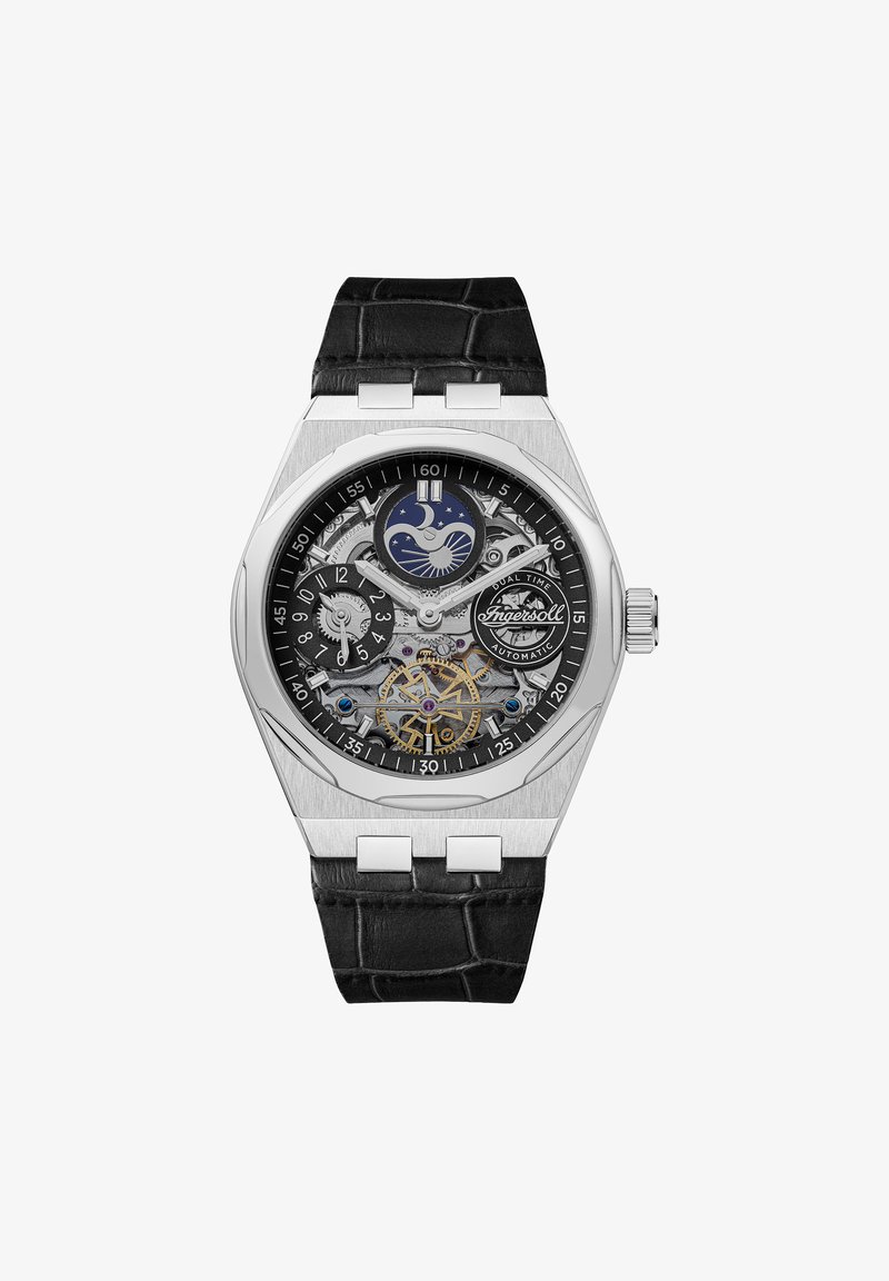 Srebrny automatyczny zegarek z czarnym paskiem ze skóry krokodyla. Posiada szkieletową tarczę, wyświetlacz podwójnego czasu oraz dekoracyjne akcenty w formie zębatek.