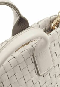 Borsa a tracolla in pelle intrecciata di colore grigio chiaro, con manico liscio, accessori dorati e superficie testurizzata. Design compatto con chiusura a zip.