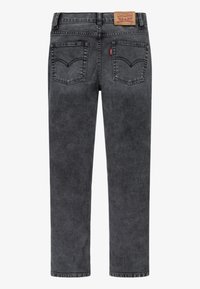 Vaqueros de mezclilla negra con corte recto, que presentan bolsillos traseros con costura, una etiqueta de cuero con la marca en la cintura y una textura suave.