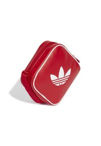 Borsetta rossa con zip realizzata in materiale sintetico liscio. Presenta piping bianco a contrasto e un grande logo bianco con tre strisce e tre foglie.