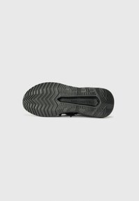 Black sneaker sole featuring a zigzag tread pattern. The brand name "KARL LAGERFELD" is embossed in the center. Durable rubber material.