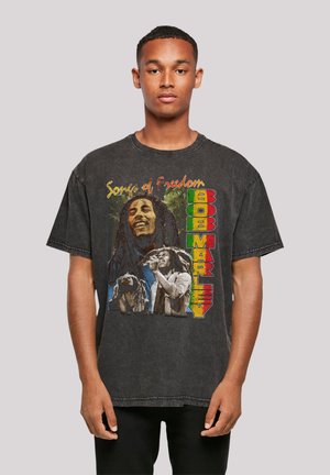 Black graphic t-shirt featuring "Songs of Freedom" and Bob Marley visuals, including colorful text and detailed images of Marley and musicians.