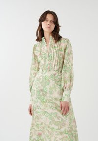 Langärmliges Blumenkleid aus leichtem Stoff, mit grünen und rosa Paisleymustern, einem gefältelten Vorderteil und einer Knopfdetail am Kragen.