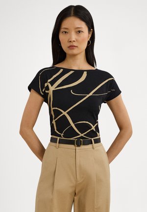Čierne tričko s abstraktným zlatým líniovým dizajnom, okrúhlym výstrihom, krátkymi rukávmi, v kombinácii s béžovými nohavicami s vysokým pásom a čiernym opaskom.