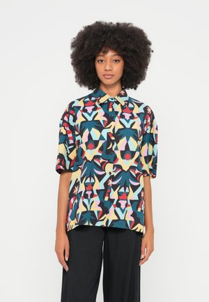 Chemise à manches courtes avec boutons, présentant un motif abstrait coloré dans des tons de bleu, rouge, jaune et rose ; tissu léger et coupe décontractée.