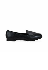 Zapatos planos negros hechos de material sint�ético texturizado, con puntera suave y un tacón ligeramente elevado, y suela de caucho antideslizante.