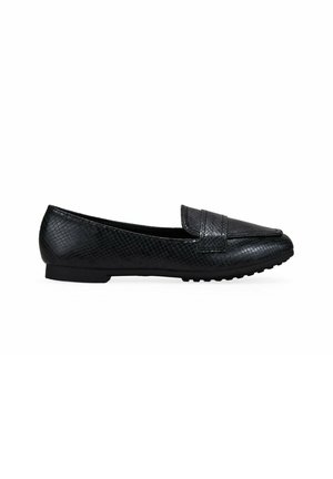 Zapatos planos negros hechos de material sintético texturizado, con puntera suave y un tacón ligeramente elevado, y suela de caucho antideslizante.