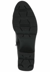 Sole di scarpa nera in gomma con un motivo esagonale testurizzato e scanalature per trazione. Tacco leggermente elevato; taglia segnata 41.