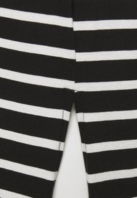 Mustavalkoiset raidalliset kankaat pehmeällä pinnalla, joissa vuorottelevat leveät ja kapeat raidat. Saumadetaili keskiselässä.