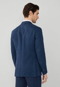 Marinblå linneblazer med en enda ventil, skräddarsydd passform och detaljer med fyraknappar vid manschetterna. Den släta texturen och den minimalistiska designen framhäver hantverket.