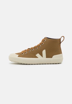 Sneakers alte marroni in tela con punta in gomma bianca e suola testurizzata, dotate di un evidente logo bianco laterale e lacci.