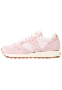 Sneakers en suédine et mesh rose clair avec lacets blancs, semelle intermédiaire crème, semelle extérieure en caoutchouc marron, et logo de la marque sur le talon et le panneau latéral.