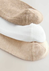 Tre par ankelsockor i ljusbeige, vit och en mörkare beige. Texturerad tyg med en slät finish och förstärkta tår.