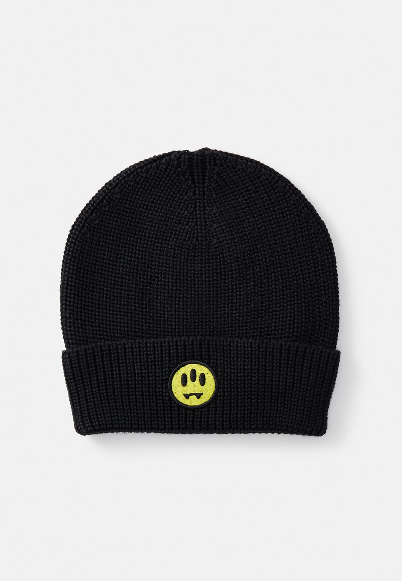 Berretto lavorato a maglia nero con una texture a coste. Presenta un viso sorridente giallo ricamato con zanne al centro del bordo ripiegato.
