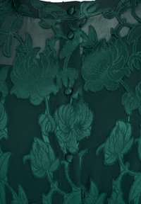 Zelená priesvitná blúzka s kvetinovým vzorom, vyšívanými listami, zapínan�ím na gombíky a textúrovanou látkou s vrstveným vzhľadom.