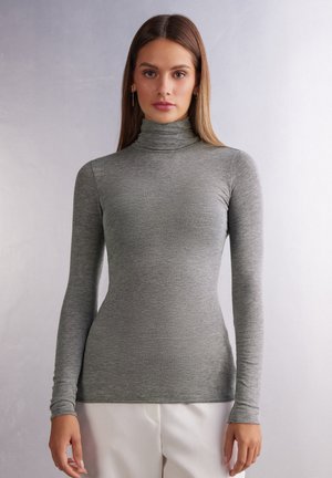 Turtlenecks långärmad skjorta gjord av mjukt, elastiskt grått tyg. Slät textur med figurnära design och inga synliga mönster.