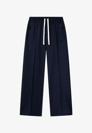 Temno modre sproščene hlače z elastičnim pasom, belim vrvico za zategovanje, žepki z zadrgo na straneh in subtilnim vezenim logotipom na zgornjem desnem stegnu.