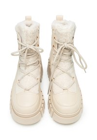 Beżowe ocieplane buty z teksturowaną powierzchnią, kołnierzem z sztucznego futra i gumową podeszwą. Ozdobione złotym, dekoracyjnym okuciem i sznurowadłami.