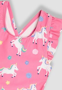 Maillot de bain rose avec un motif de licorne et des volants aux épaules, fabriqué en tissu doux et extensible. Les couleurs accentuées incluent le bleu et le jaune.