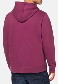 Fioletowy hoodie z kieszenią kangurką, wykonany z bawełny, z prążkowanymi mankietami i dolnym brzegiem oraz kapturem ze sznurkiem, wyświetlany z tyłu.