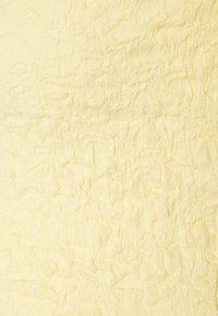 Texturerat gult tyg med ett veckat mönster, mjuk yta och lätt vikt, lämpligt för kläder eller heminredningsapplikationer.