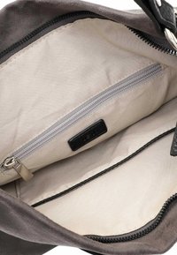Grau Wildleder-Handtasche Innenraum mit hellbeigem Futter, verfügt über eine Reißverschluss-Tasche und schwarze Lederakzente. Reißverschlussverschluss entlang der oberen Kante.