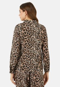 Camicia a maniche lunghe in tessuto leggero, con stampa leopardata marrone e nera, design con colletto, vestibilità rilassata e dettagli con bottoni sui polsini.