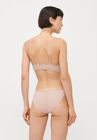 Light pink, soft fabric bralette and matching bikini bottom. Simple design with thin straps and seamless edges.