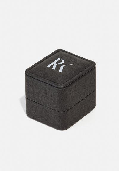Cutie pătrată din piele sintetică neagră, cu margini cusute și un logo alb „RK” embosat pe suprafața superioară.