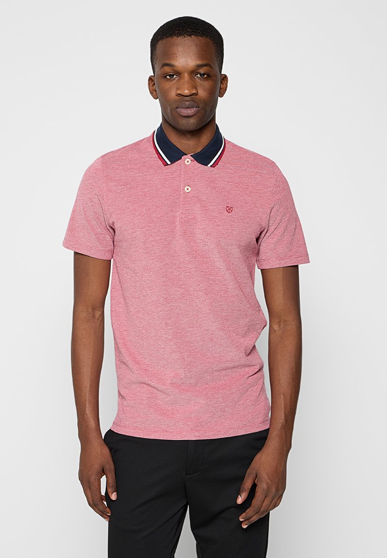 Polo rojo texturizado de manga corta, con un cuello azul marino con franjas blancas y rojas y un pequeño logotipo en el lado izquierdo del pecho.