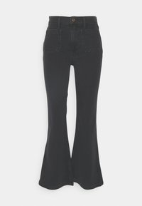 Sorte utsvingte jeans laget av denim, med høy midje, fem-lommer design og splitt nederst for ekstra detaljer.