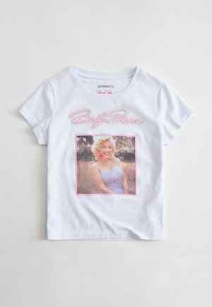 T-shirt blanc à manches courtes avec une photo souriante de Marilyn Monroe dans un cadre rose et le texte « Marilyn Monroe » en cursive rose au-dessus.